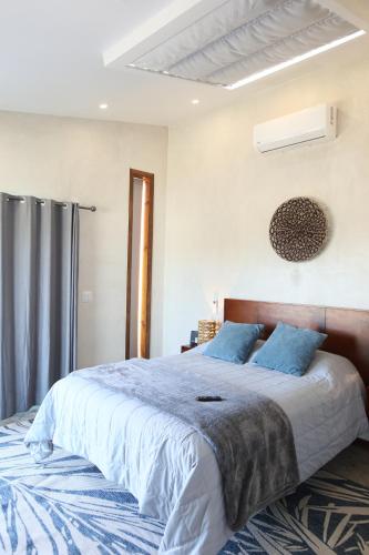 a bedroom with a large bed with blue pillows at Sarab Hotel in Ensenada