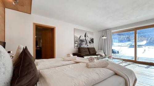 a bedroom with a large bed and a large window at Monte Vita Tirol - Apartments in Biberwier