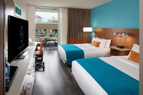 a hotel room with two beds and a flat screen tv at Shore Hotel in Los Angeles