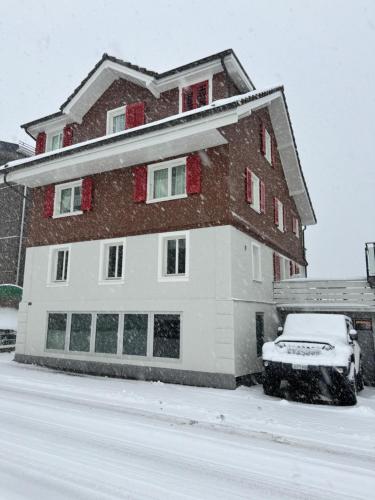 a snow covered house with a car parked in front of it at Bijou N 2 Lungern in Lungern