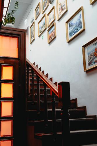 a staircase with framed pictures on the wall at Bark Inn - Bed and Breakfast in Braşov