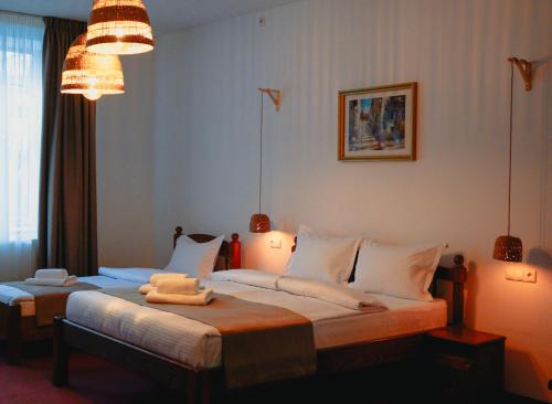 a bedroom with two beds with towels on them at Bark Inn - Bed and Breakfast in Braşov