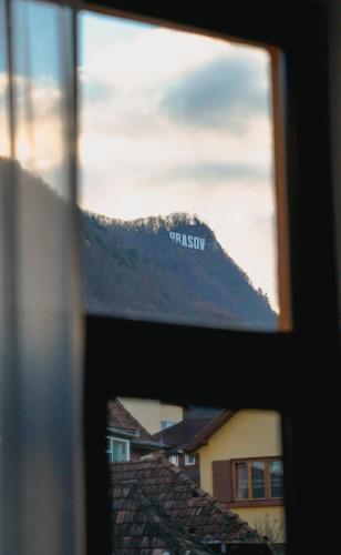 a view of a mountain through a window at Bark Inn - Bed and Breakfast in Braşov