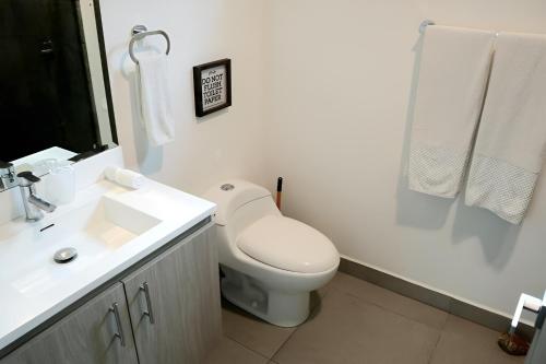 a bathroom with a toilet and a sink and a shower at Tranquil Tides Costa Rica in Pochote