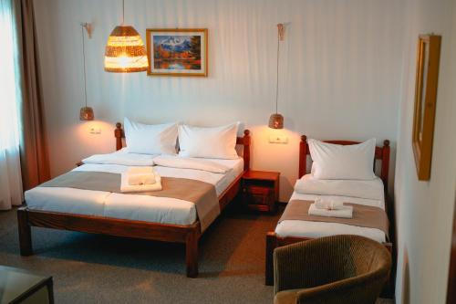 a hotel room with two beds and a chair at Bark Inn - Bed and Breakfast in Braşov
