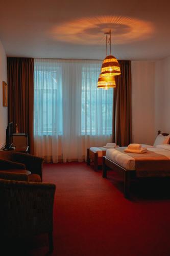 a hotel room with two beds and a chandelier at Bark Inn - Bed and Breakfast in Braşov