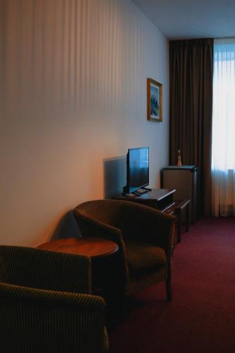 a hotel room with two chairs and a television at Bark Inn - Bed and Breakfast in Braşov