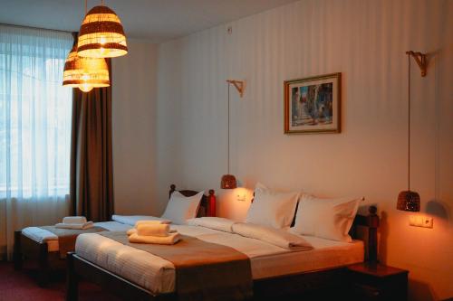 a bedroom with two beds and a chandelier at Bark Inn - Bed and Breakfast in Braşov