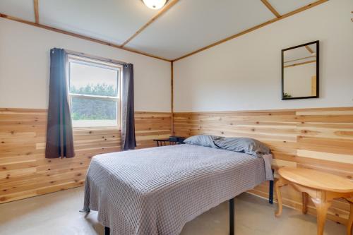 a bedroom with a bed in a wooden room at Toivola Home with Fire Pit 8 Mi to Lake Superior! in Toivola