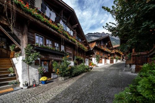a cobblestone street in front of a building with flowers at Large apt in town center next to Brunngasse & near lake in Brienz