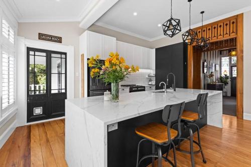 a kitchen with a large island with a vase of flowers at Luxury Villa on Napier Hill in Napier