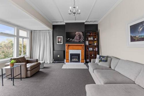 a living room with a couch and a fireplace at Luxury Villa on Napier Hill in Napier