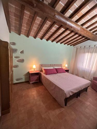 a bedroom with a large bed in a room with wooden ceilings at Antica Vigna Toscana in Poppi