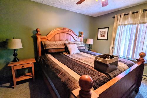 a bedroom with a large bed with a wooden headboard at Frost Hollow by AvantStay Deck w Grill Game Room Loft in White Haven