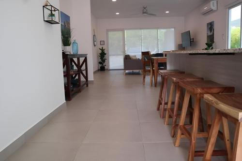 a dining room with wooden tables and a bar at Tranquil Tides Costa Rica in Pochote
