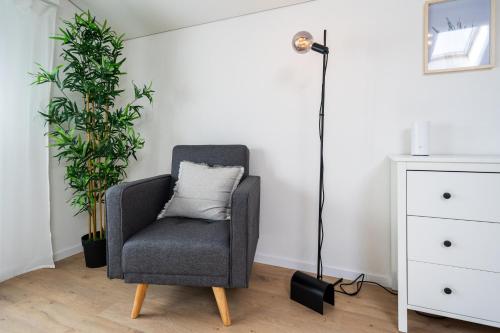 a living room with a chair and a floor lamp at Large apt in town center next to Brunngasse & near lake in Brienz