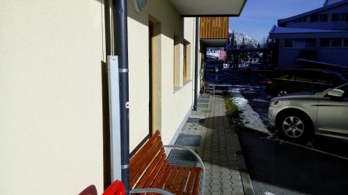 a red bench sitting on the side of a building at Apartments Blažič in Kranjska Gora