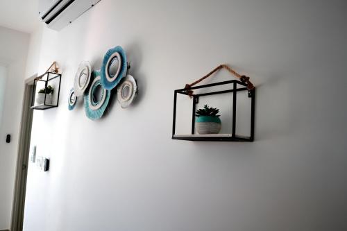 a white wall with a shelf with clocks on it at Tranquil Tides Costa Rica in Pochote