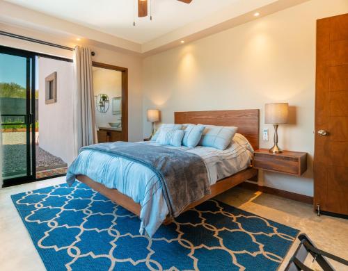 a bedroom with a large bed and a blue rug at Sarab Hotel in Ensenada