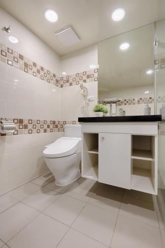 a white bathroom with a toilet and a sink at Good Life Hotel - Shang Hwa in Taipei
