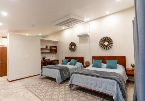 a bedroom with two beds with blue pillows at Sarab Hotel in Ensenada