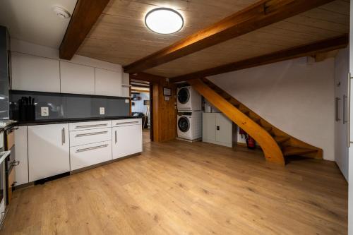 a kitchen with white cabinets and a wooden floor at Large apt in town center next to Brunngasse & near lake in Brienz