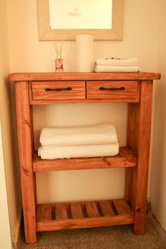a wooden shelf with towels and a mirror in a bathroom at Natullins Apartment in Ezeiza
