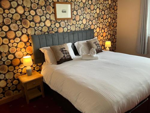 una camera da letto con un grande letto con tronchi a muro di Seaview John O Groats Hotel a John O Groats