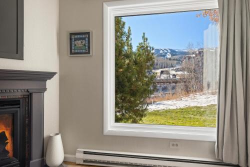 a window in a living room with a view at Woodbridge Condo by Snowmass Vacations in Snowmass Village