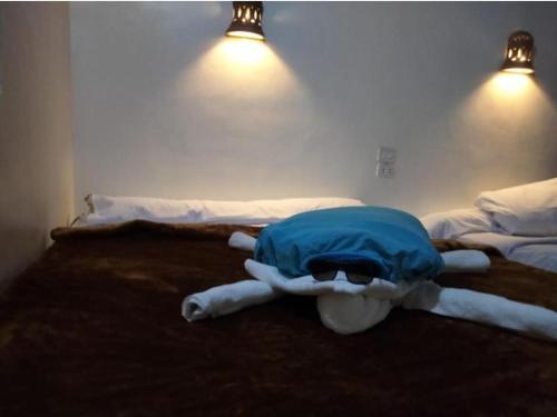 a bed with a blue blanket on top of it at Happy house Aswan in Aswan