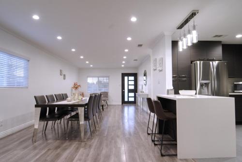 a kitchen and dining room with a table and chairs at Stylish 3BR, 2BA Home , Sleeps 8 - King Bed, Firepit, Near Universal, SoFi in Los Angeles