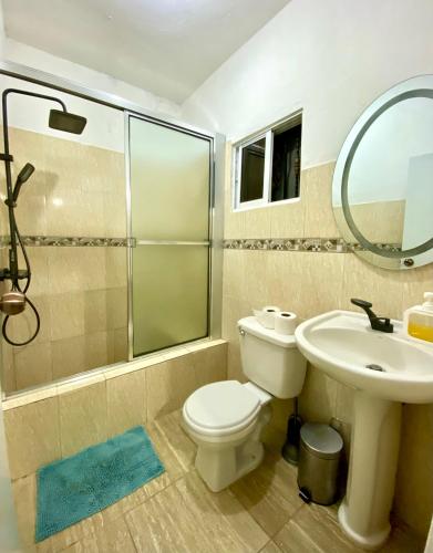 a bathroom with a toilet and a sink and a mirror at Casa Tipo Villa, Piscina, Playas De RSJ a 4 min in Río San Juan