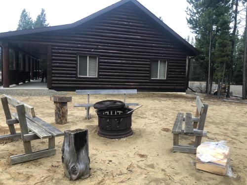 a log cabin with benches and a fire pit at Mama Bear in Valemount