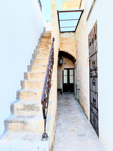 a stairway leading up to a building with a black door at The Art of Leo in Lucugnano
