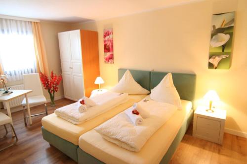 a bedroom with two beds with towels on them at Landhotel Bergischer Hof GmbH Marialinden in Overath
