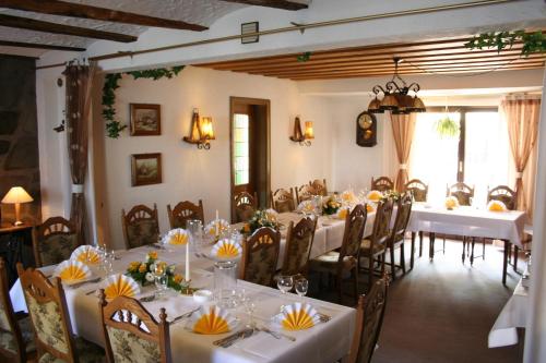 a dining room with white tables and chairs at Landhotel Bergischer Hof GmbH Marialinden in Overath