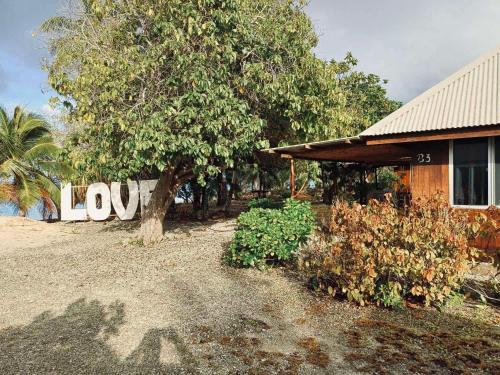 a house with a sign that says love in front of it at Monita villa Tiputa in Tiputa