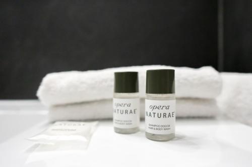 two bottles of moisturizers sitting on a table with towels at 14 minuti da Firenze Parcheggio gratuito in Scandicci