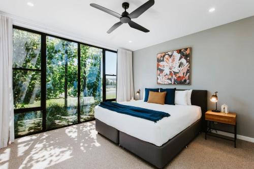 Un dormitorio con una cama y un ventilador de techo. en The Wine Manor - Lavish Poolside Living, en Mudgee