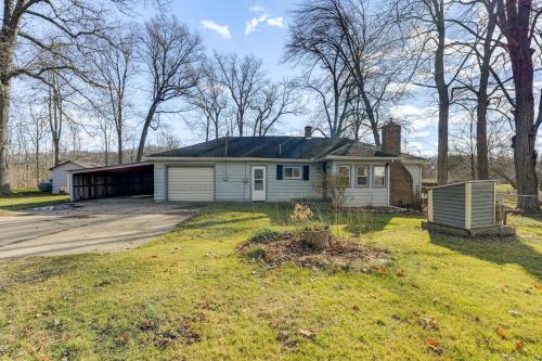 a house with a garage in a yard at Secluded Home with Lake View in Delton! in Delton