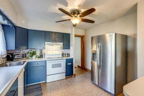 a kitchen with blue cabinets and a ceiling fan at Secluded Home with Lake View in Delton! in Delton