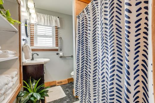 a bathroom with a shower curtain and a sink at Secluded Home with Lake View in Delton! in Delton