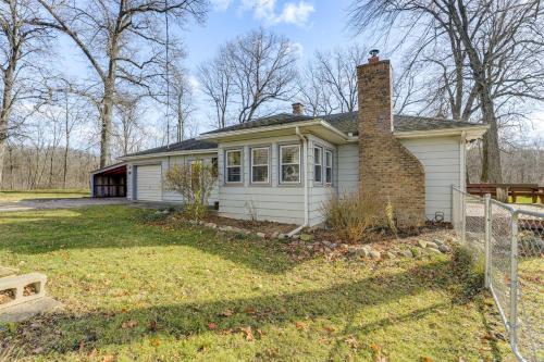 a small white house with a brick chimney at Secluded Home with Lake View in Delton! in Delton