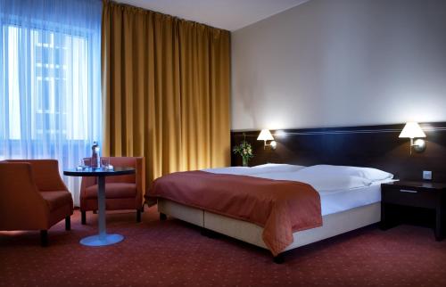 una camera d'albergo con letto, tavolo e sedia di Hotel Tatra a Bratislava