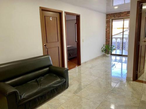 a black leather couch sitting in a living room at Apartamento Chia Centro Luna Serena in Chía