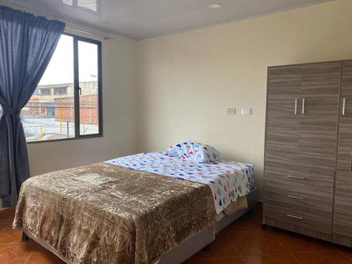 a bedroom with a bed and a dresser and a window at Apartamento Chia Centro Luna Serena in Chía