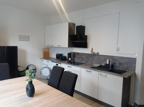 a kitchen with a sink and a table with chairs at Work and Stay 6 Zimmer 150qm 12 Betten 3 Badezimmer in Meinerzhagen