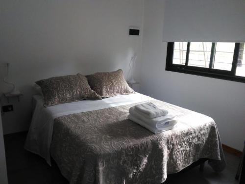 a bedroom with a bed with two towels on it at Casitas del Lago in Potrero de Garay