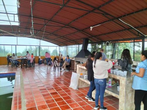 a group of people standing around in a restaurant at Casa de campo in Cogua