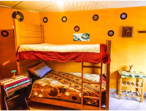 a bedroom with two bunk beds and a yellow wall at Casa de Huéspedes "La Casa Bonita" in La Paz